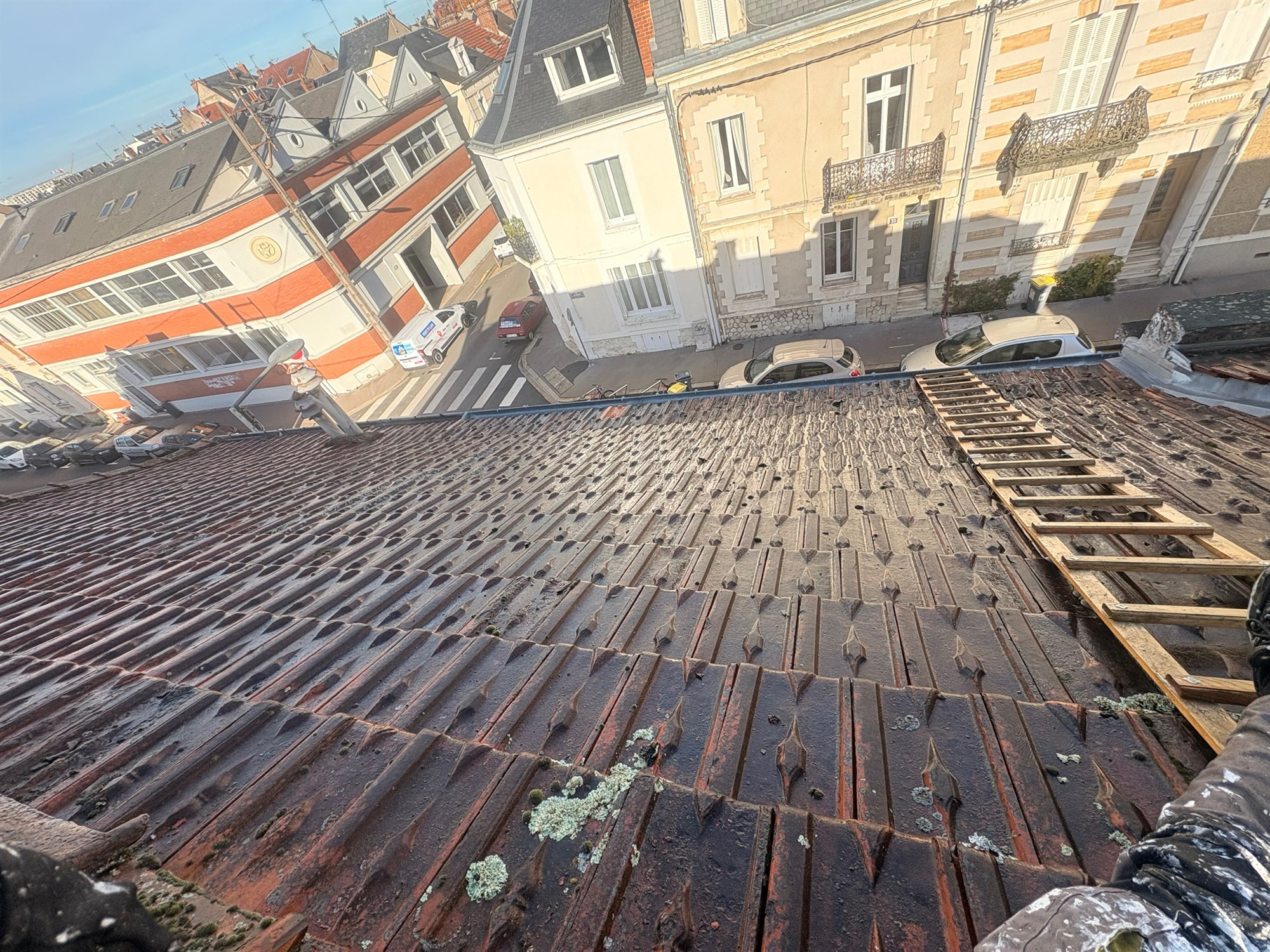 Toiture ancienne en cours de nettoyage dans une rue de ville