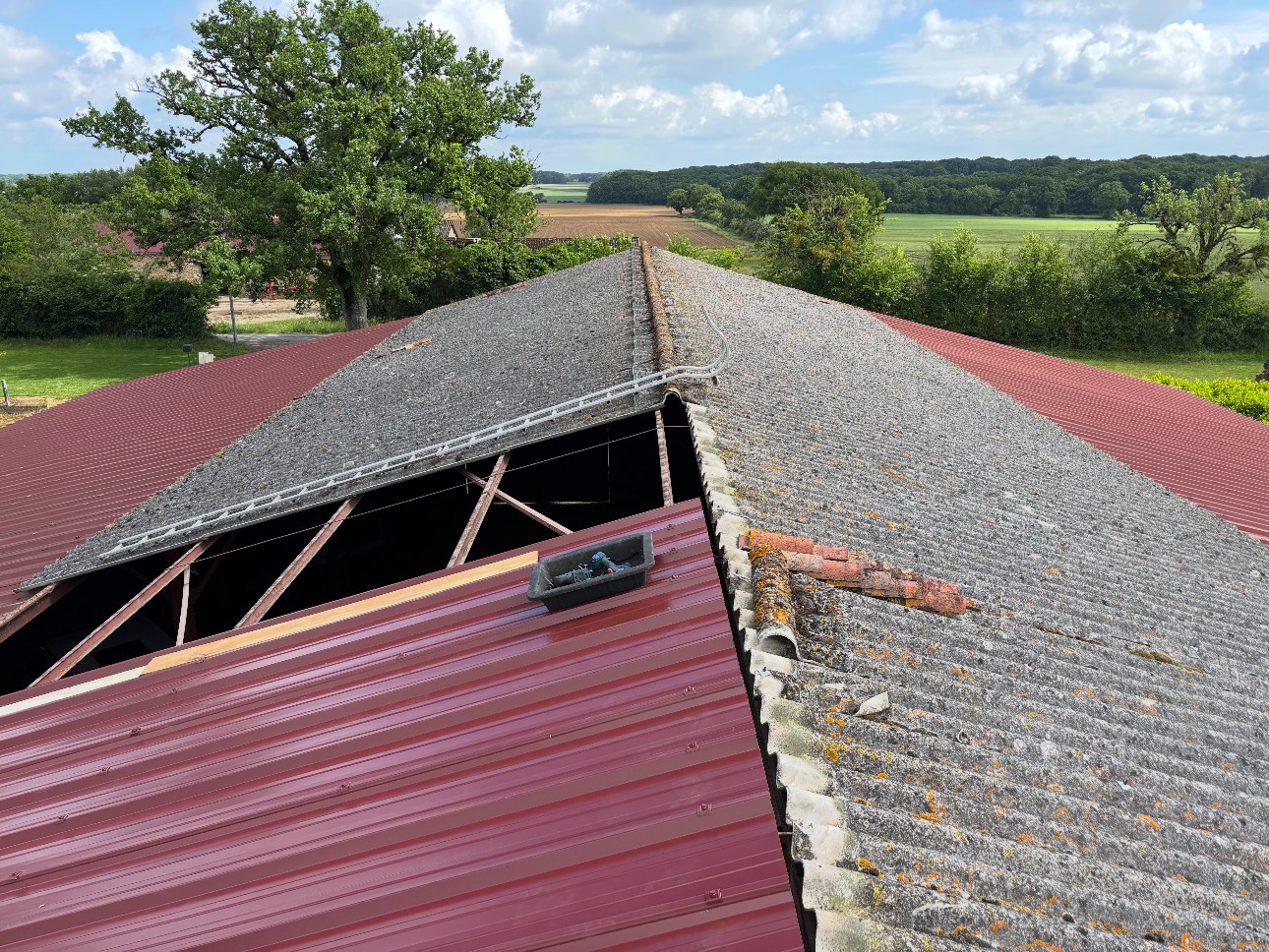 Toiture de bâtiment agricole en fibrociment ancien, partiellement déposée avant rénovation