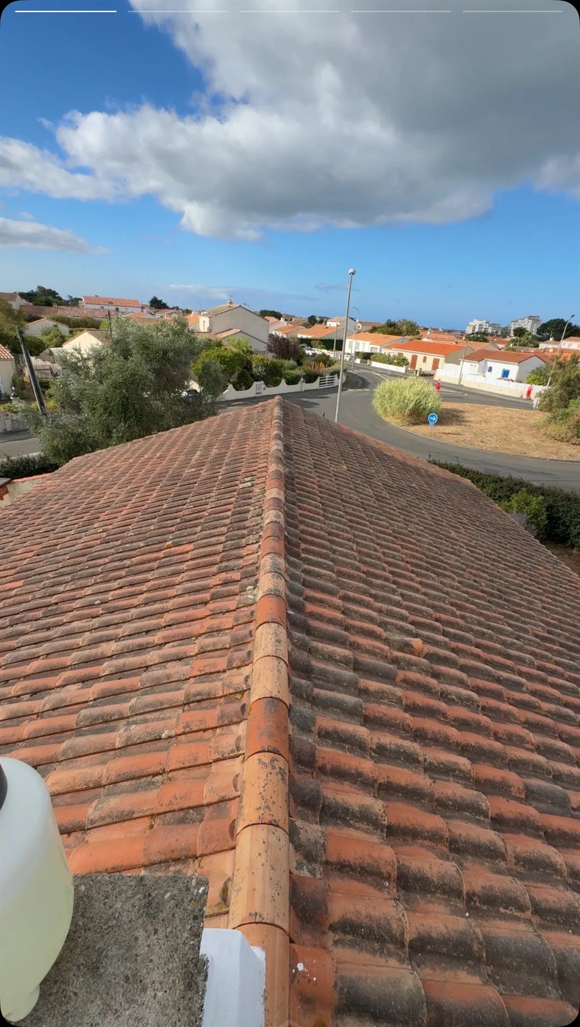 Toiture en tuiles à moitié couverte de lichen avant nettoyage